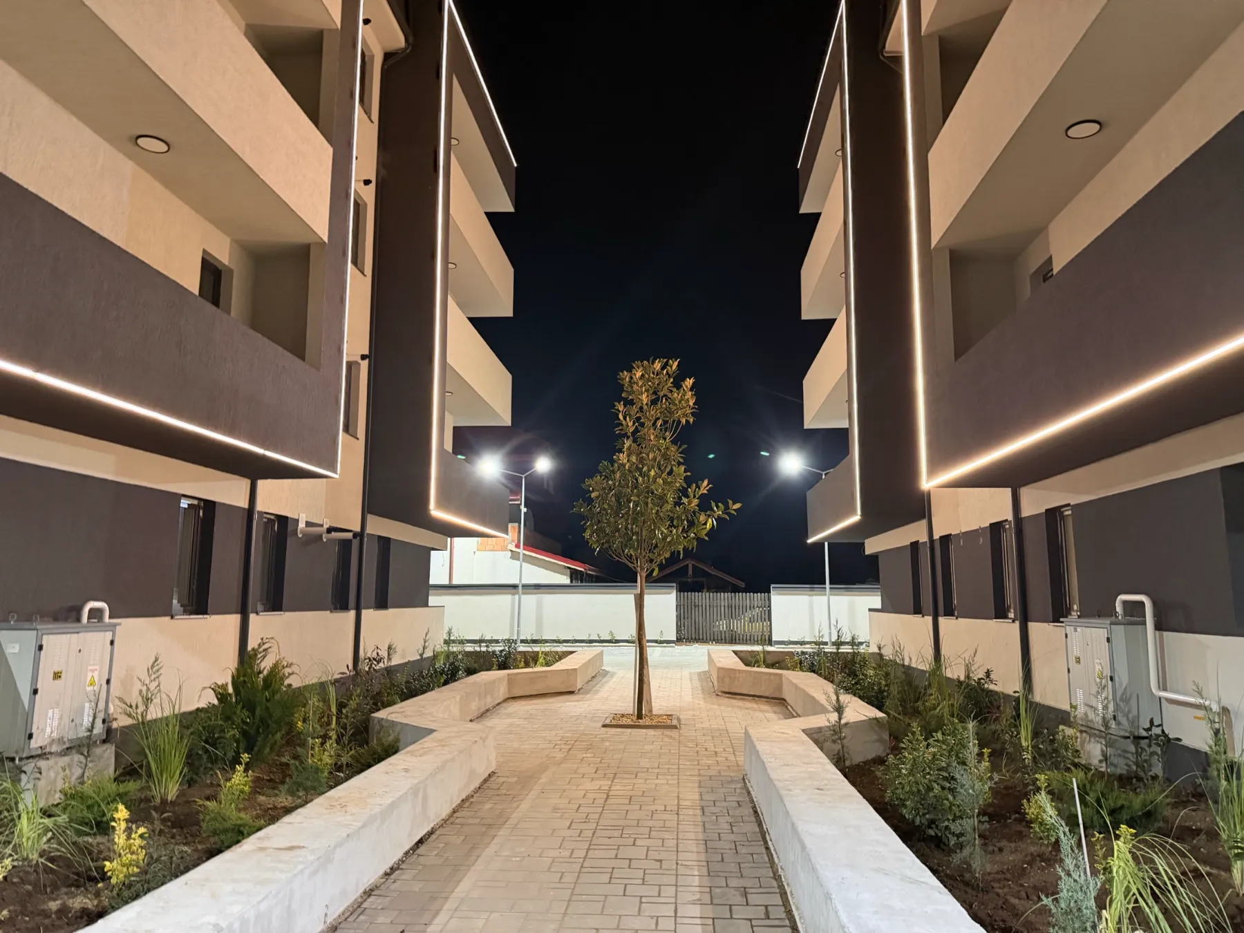 Hamilton Residence — curte interioară amenajată, iluminată seara, cu balcoane moderne